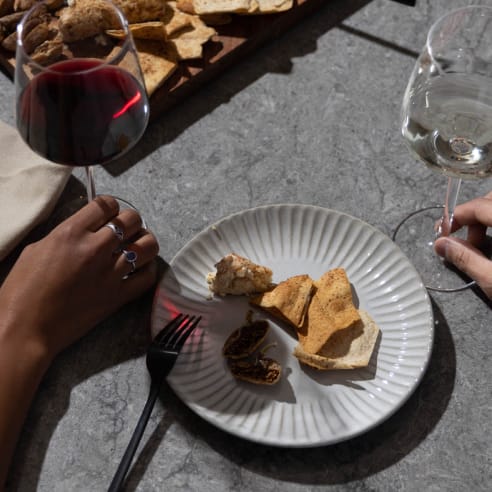 a plate of food on a table with a glass of wine